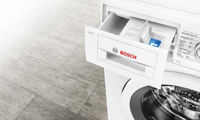 Innenansicht eines offenen Kühlschranks mit gefrorenem Fisch, rotem Frostglas und verschiedenen verpackten verderblichen Lebensmitteln.